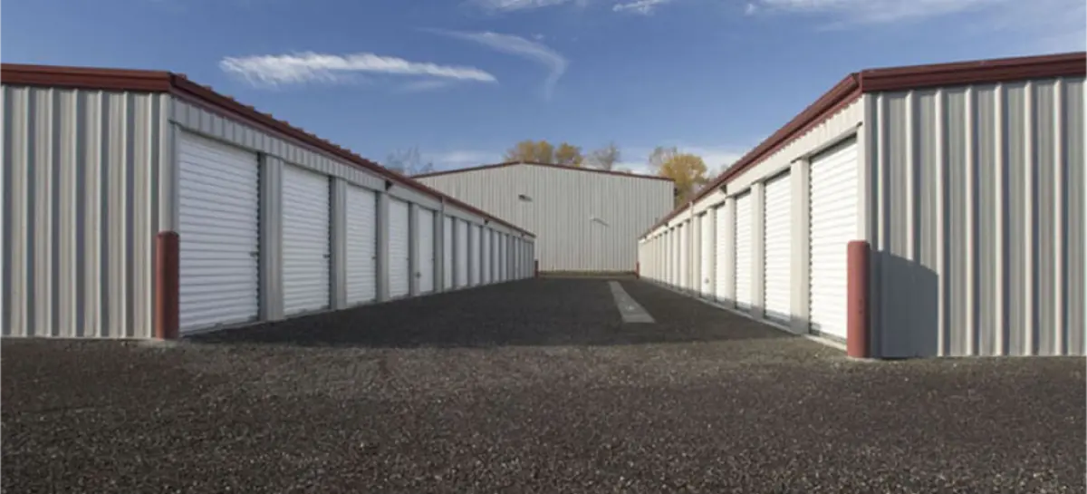 A row of storage units lined up next to each other on a sunny day.