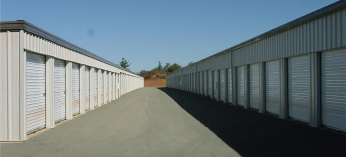 A row of storage units are lined up on the side of a road.