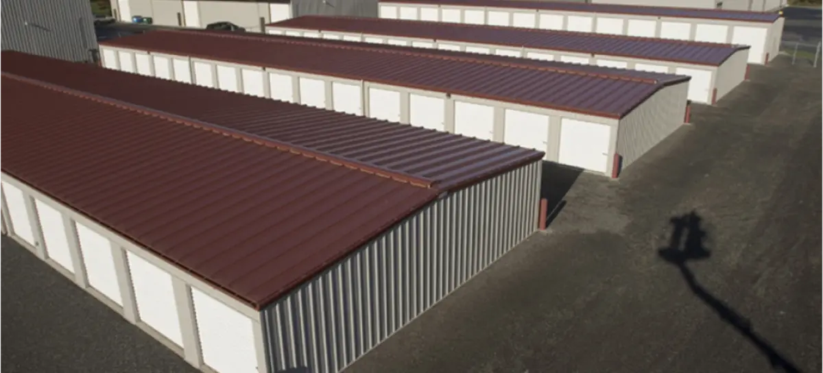 A row of storage units with a red roof