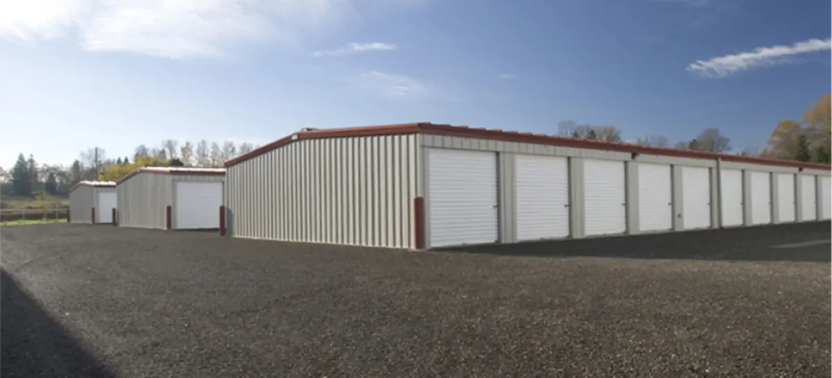 A row of storage units with white doors on a sunny day.