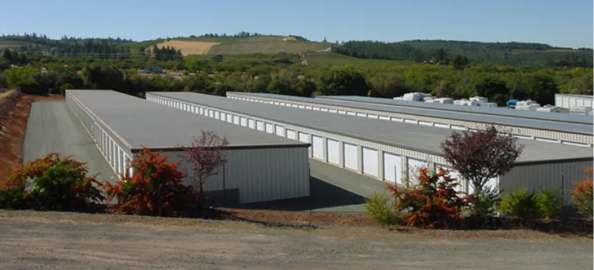 A row of storage units are lined up in a parking lot.