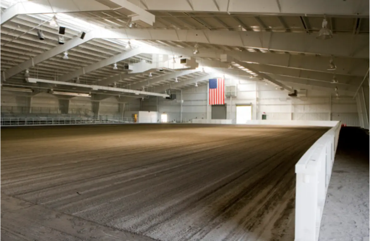 A large indoor arena with an american flag hanging from the ceiling