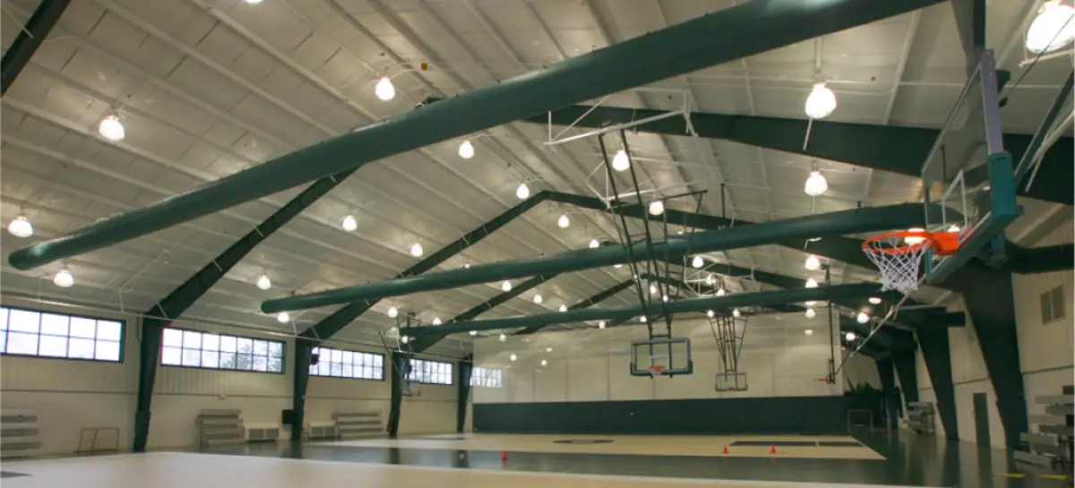 A basketball hoop is hanging from the ceiling of a gym.