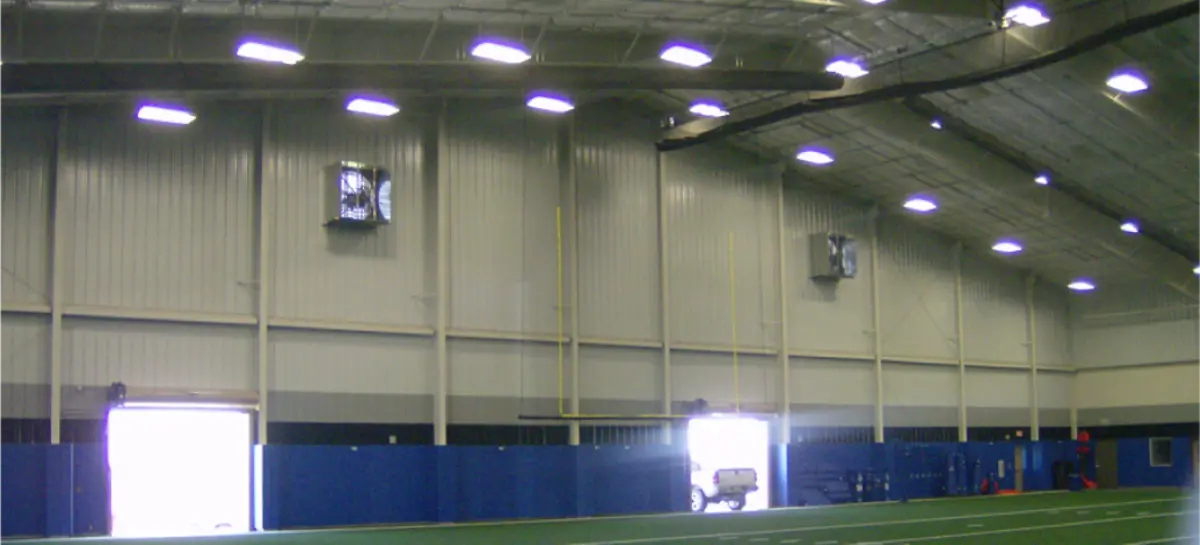 The inside of a large indoor stadium with a football field.