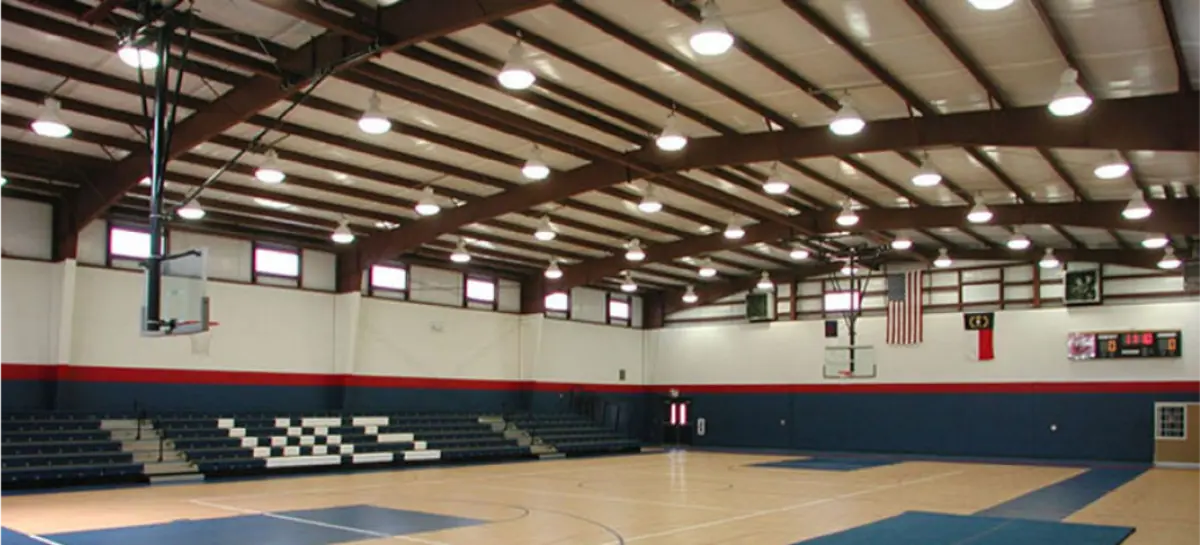 A large indoor gym with a basketball court and bleachers