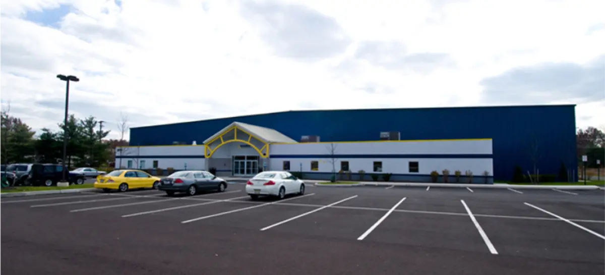 A blue and white building with cars parked in front of it