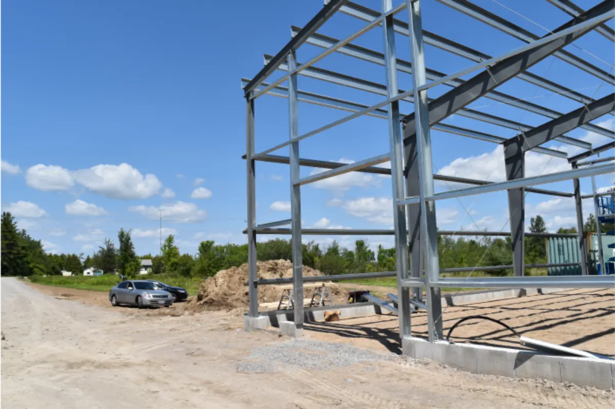 A car is parked in front of a building under construction