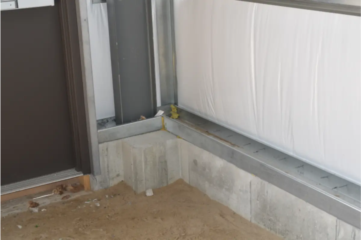 A corner of a building with a door and a wall.