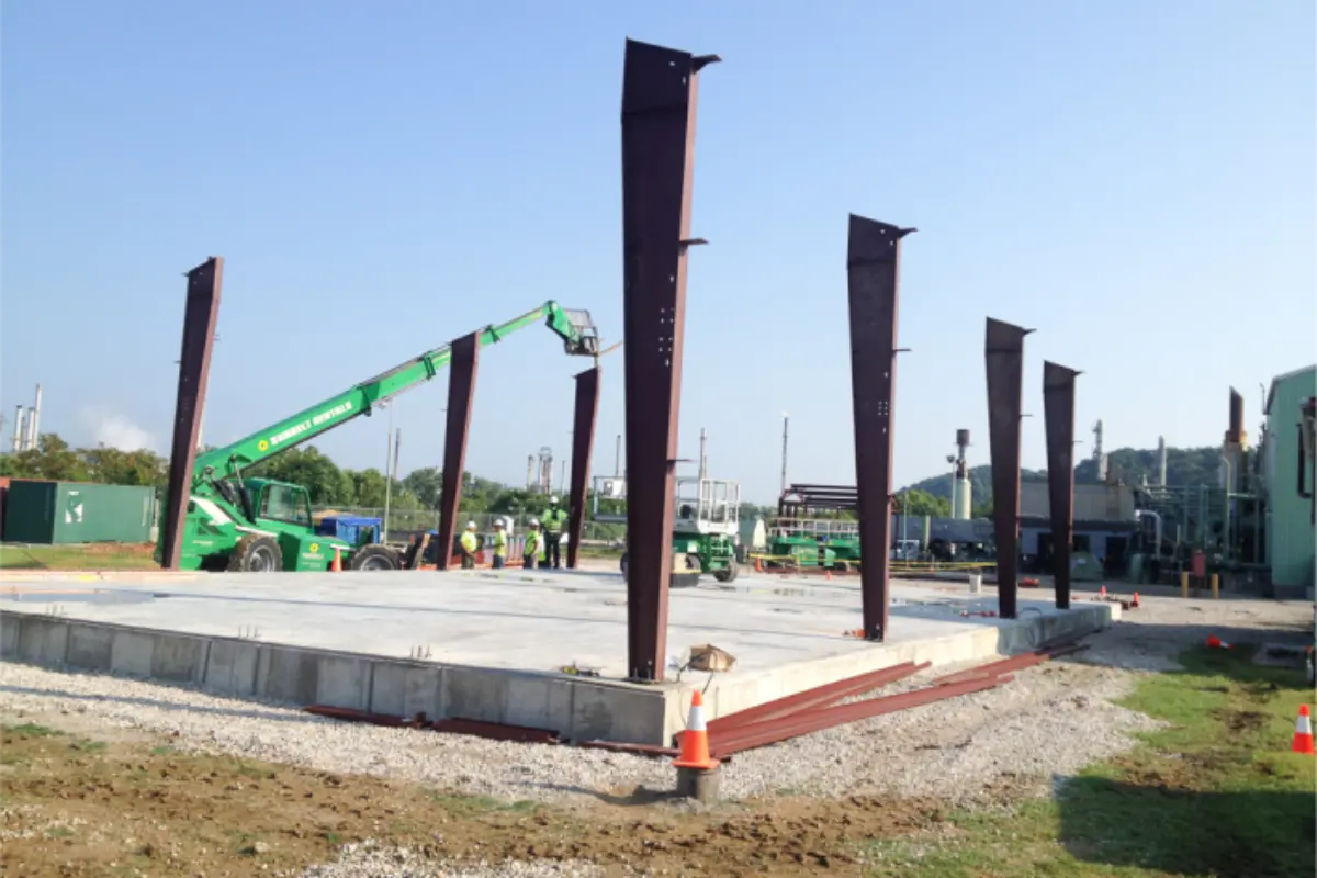 A construction site with a green crane in the background