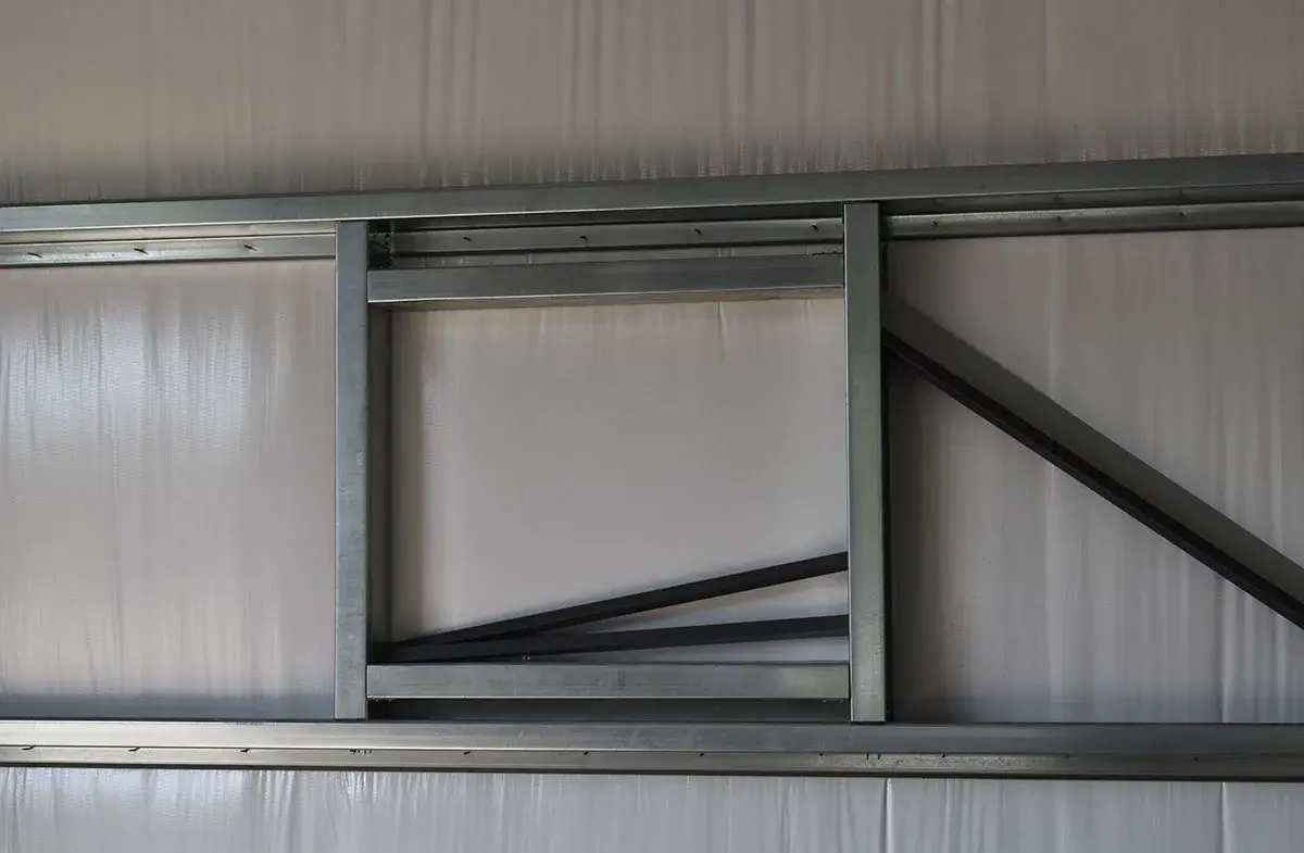 A metal ladder is hanging on a white wall.