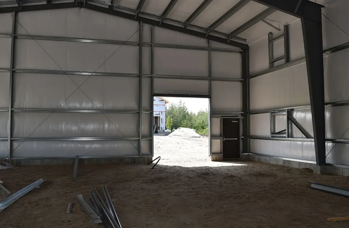 The inside of a building under construction with a door open.