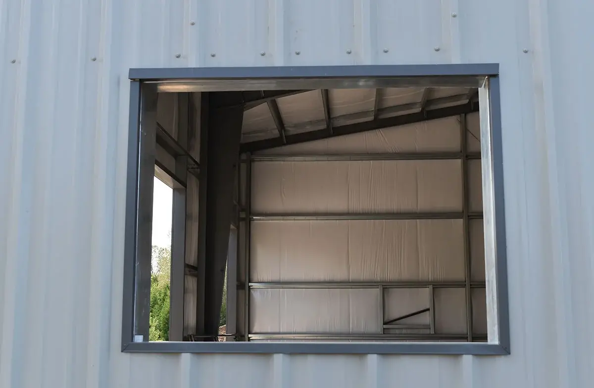 A window in the side of a building with a metal frame