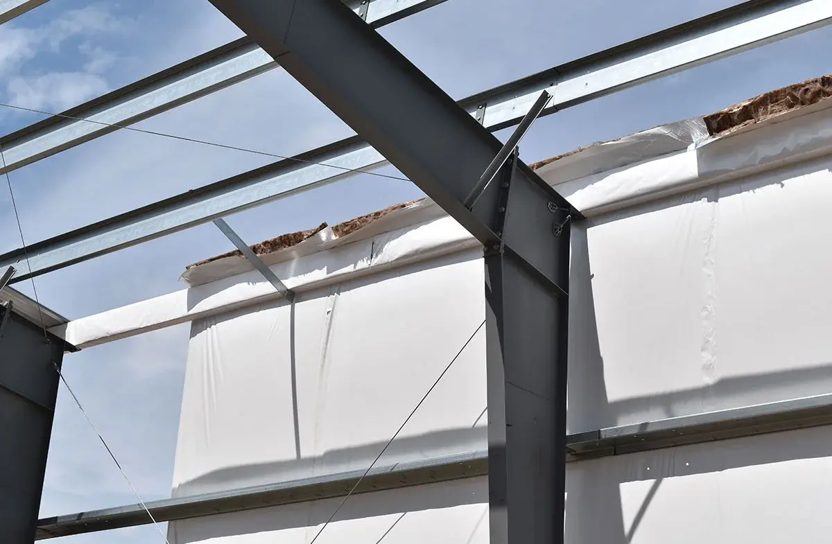 A metal structure is being built on top of a white building.