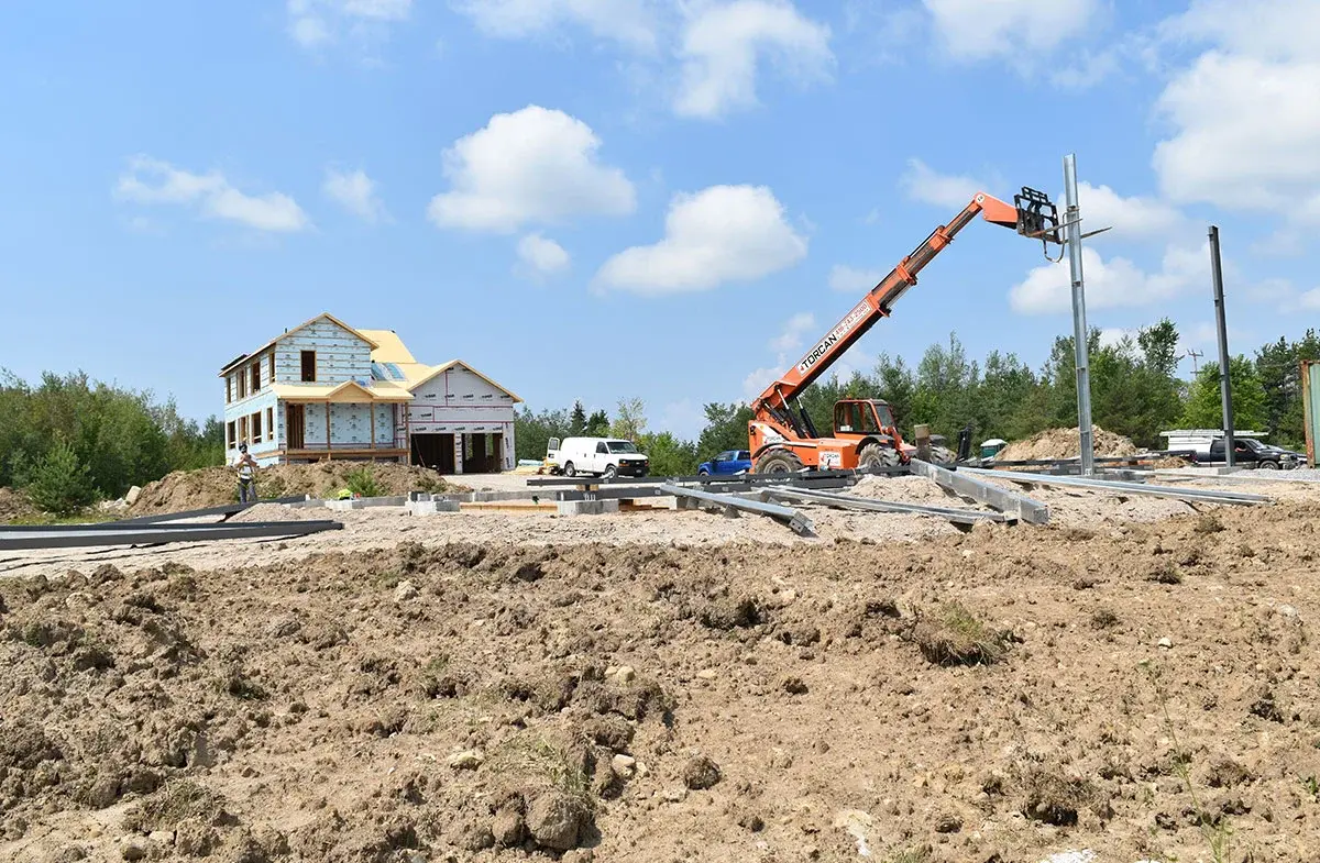 A house is being built in the middle of a dirt field.