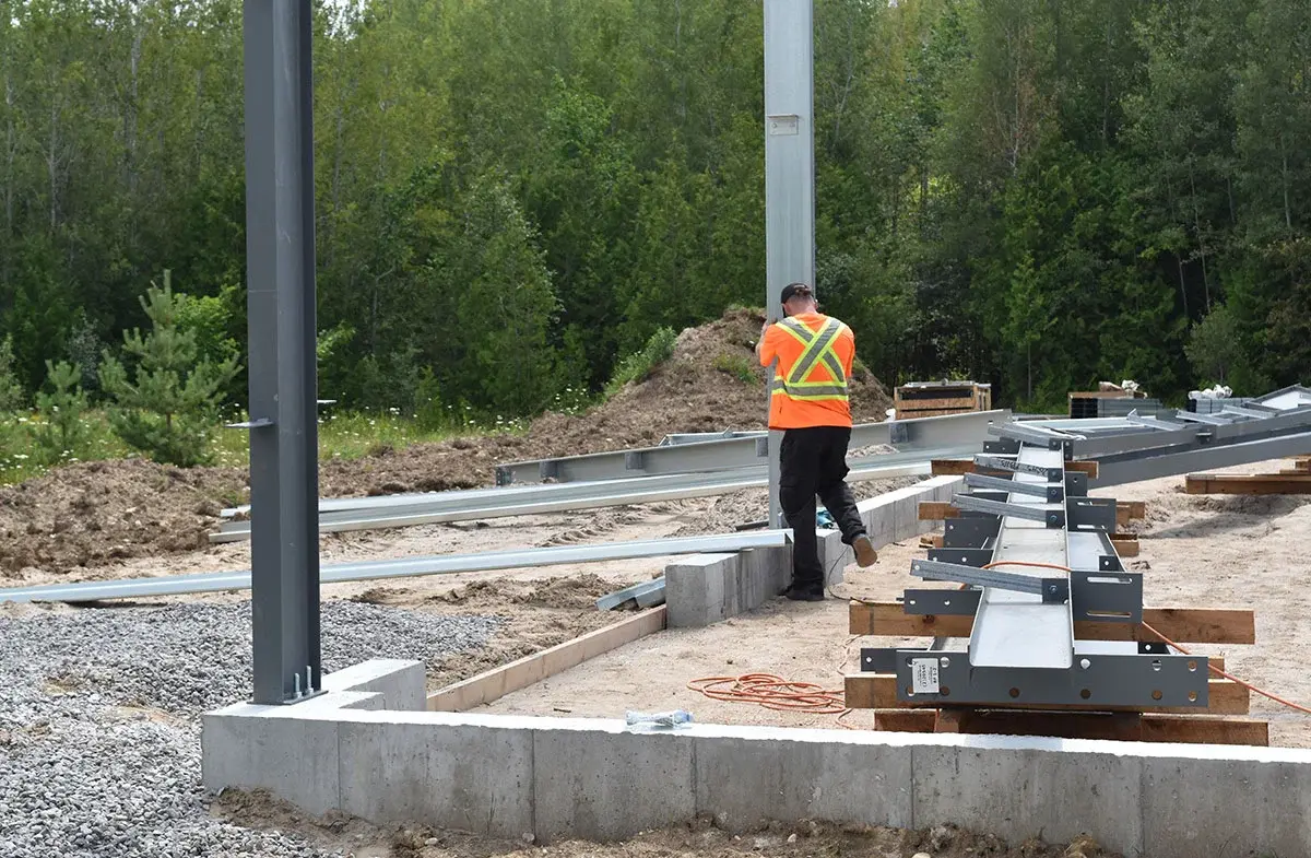 A man in an orange vest is working on a construction site.
