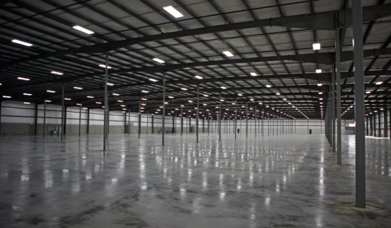 An empty warehouse with a lot of lights on the ceiling