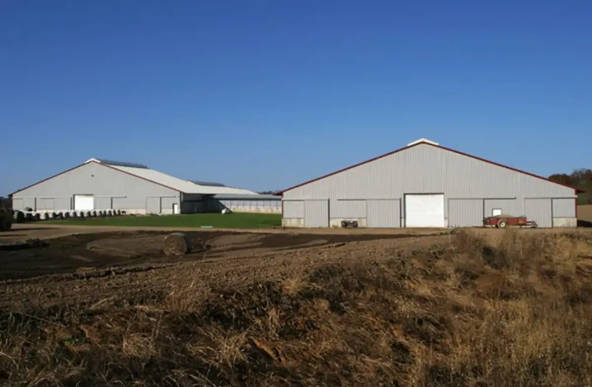 There are two buildings in the middle of a field.