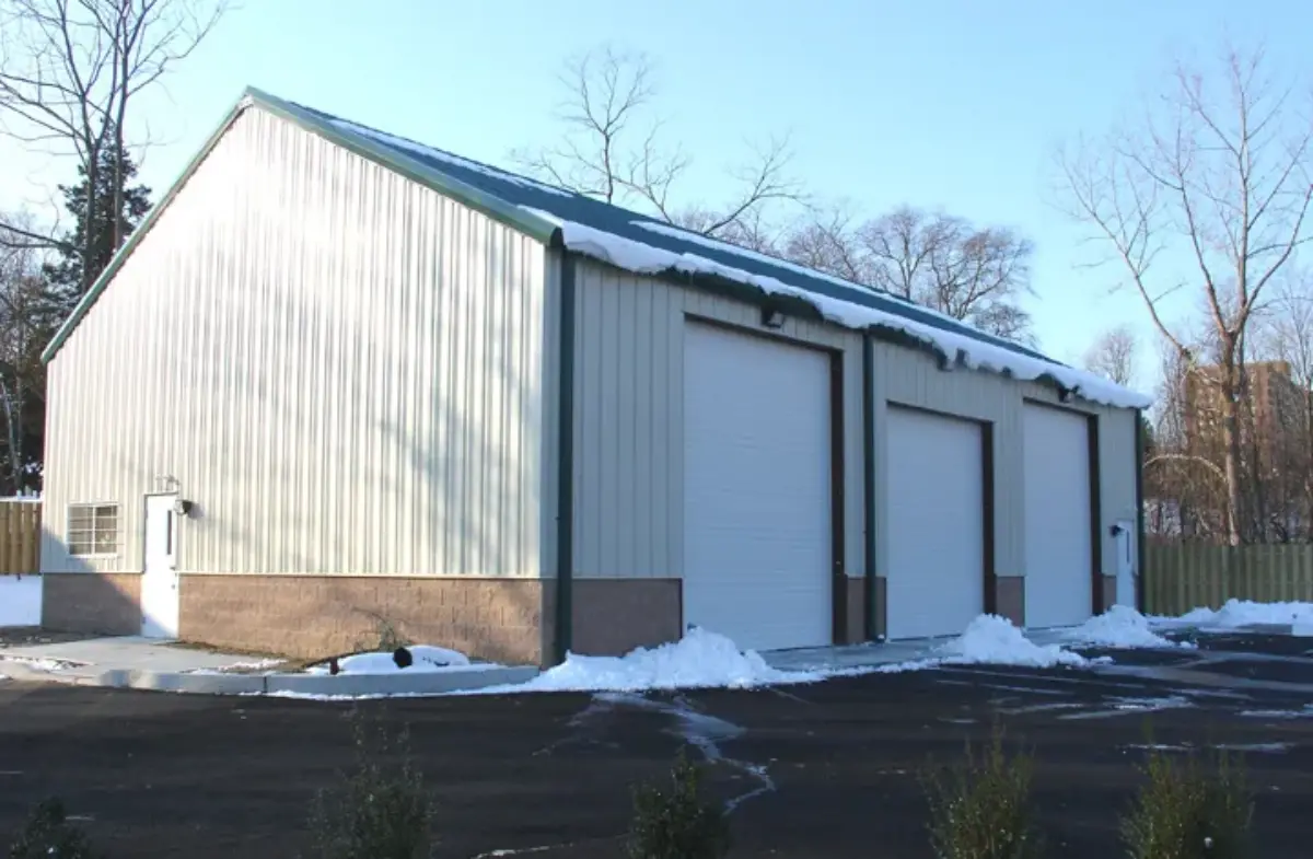 A white building with a green roof and white doors