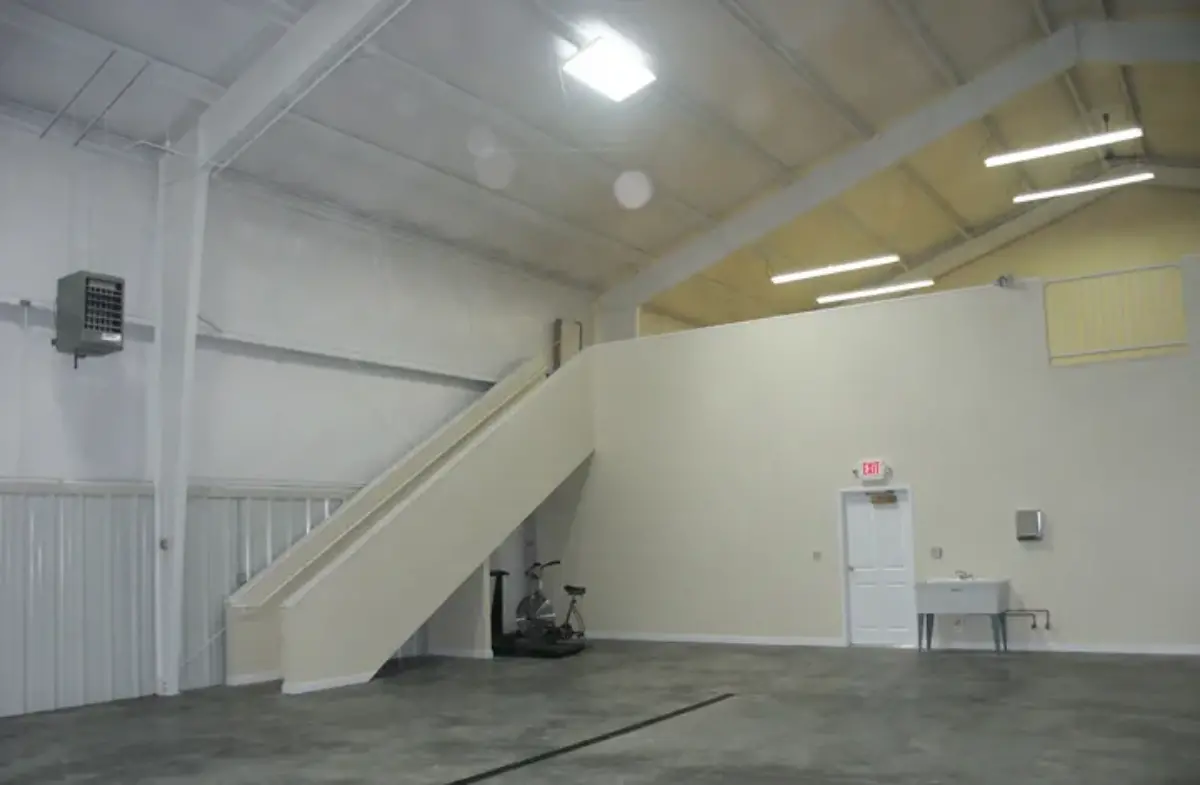 An empty warehouse with a staircase leading up to the second floor