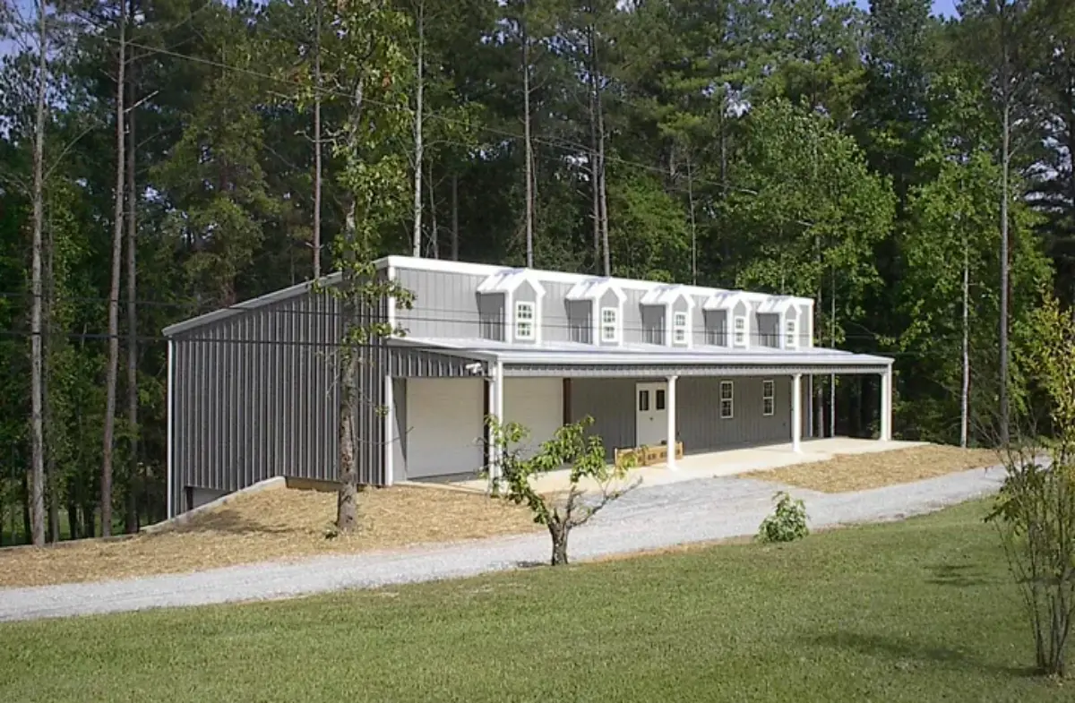 A house with a porch is surrounded by trees and grass