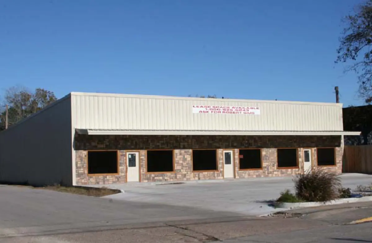 A white building with a sign that says ' new tropics ' on it