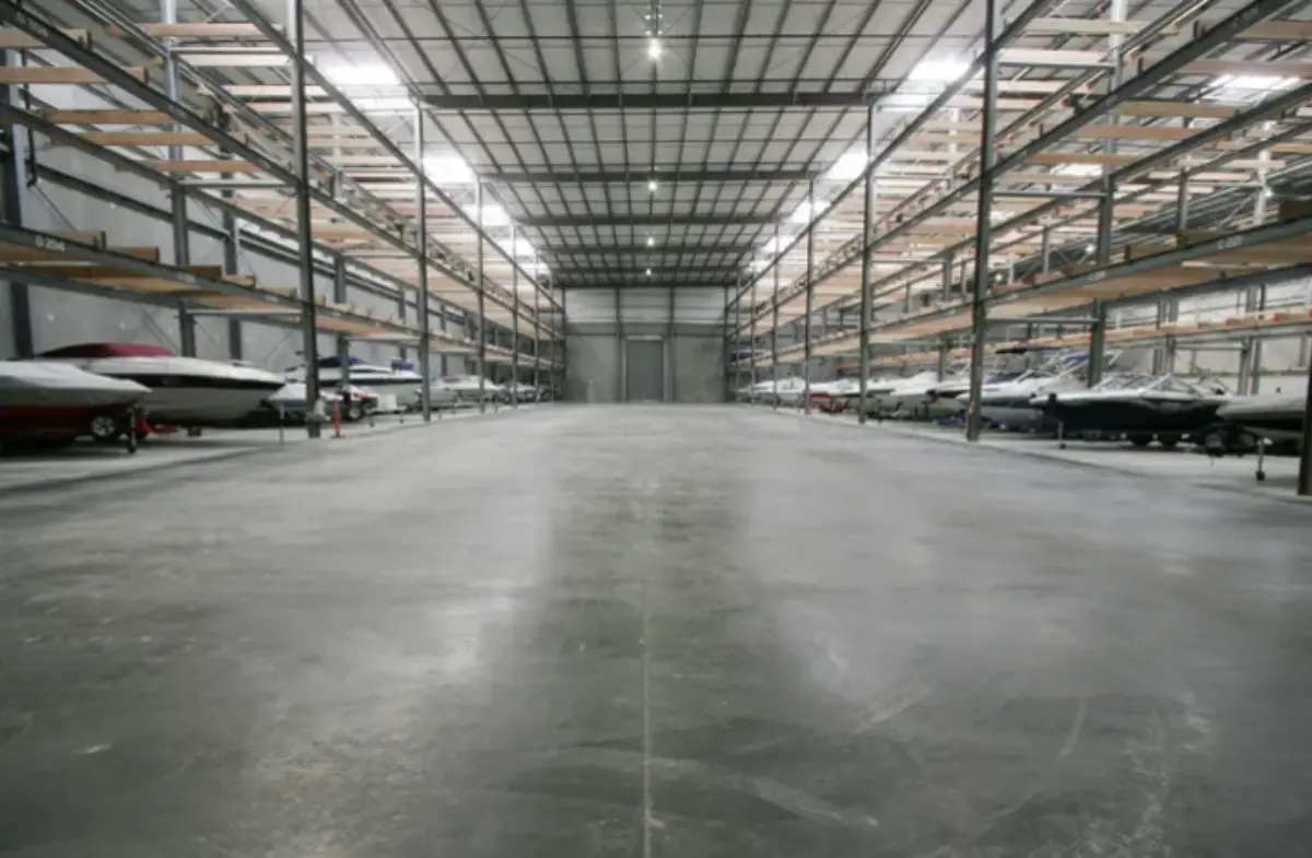 A large warehouse filled with lots of boats and cars.