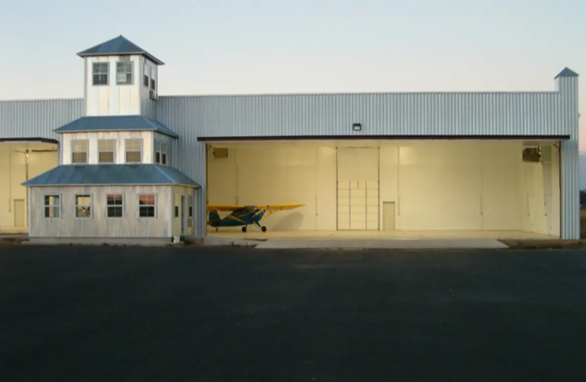 A small plane is parked in front of a building