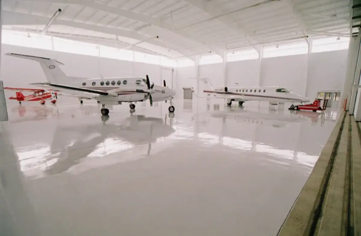 Two small planes are parked in a hangar.