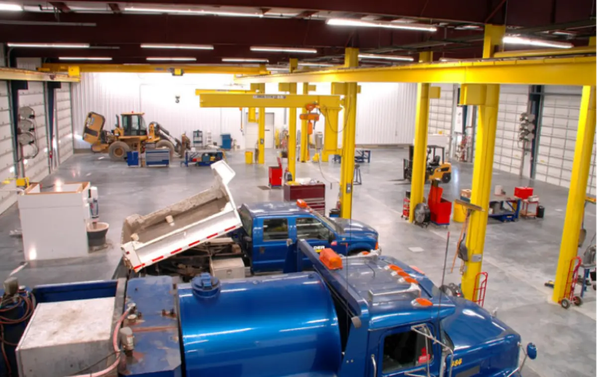 A blue dump truck is parked in a warehouse