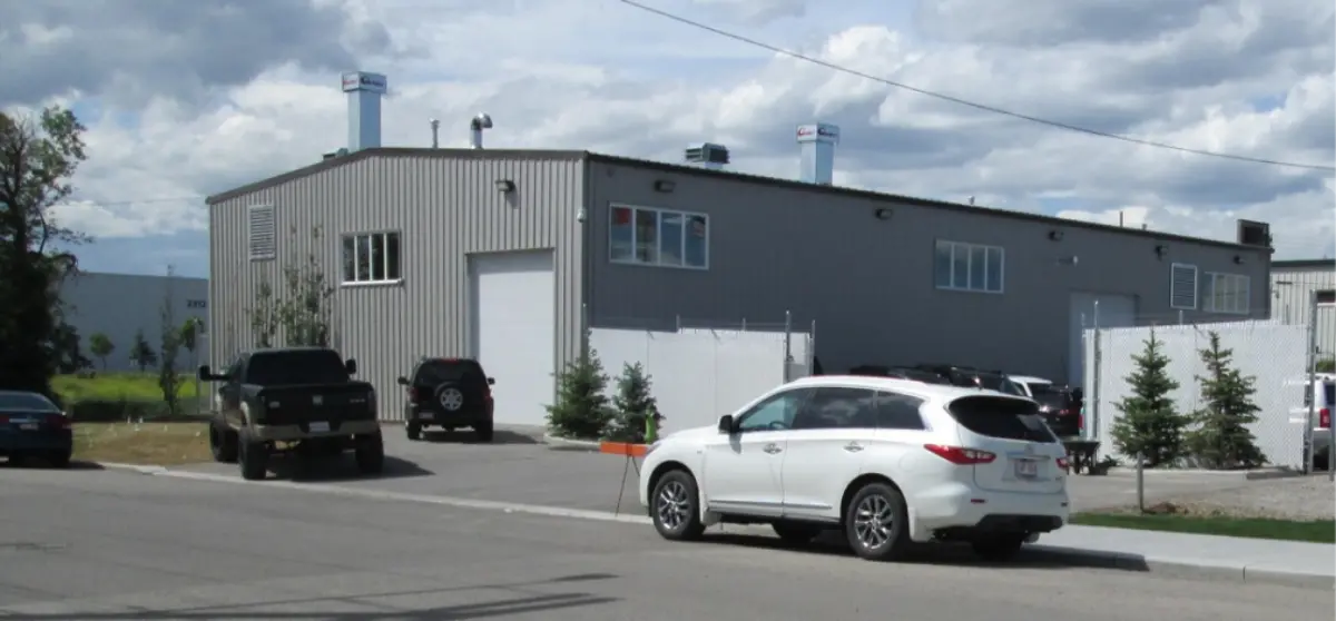 A white suv is parked in front of a large building.