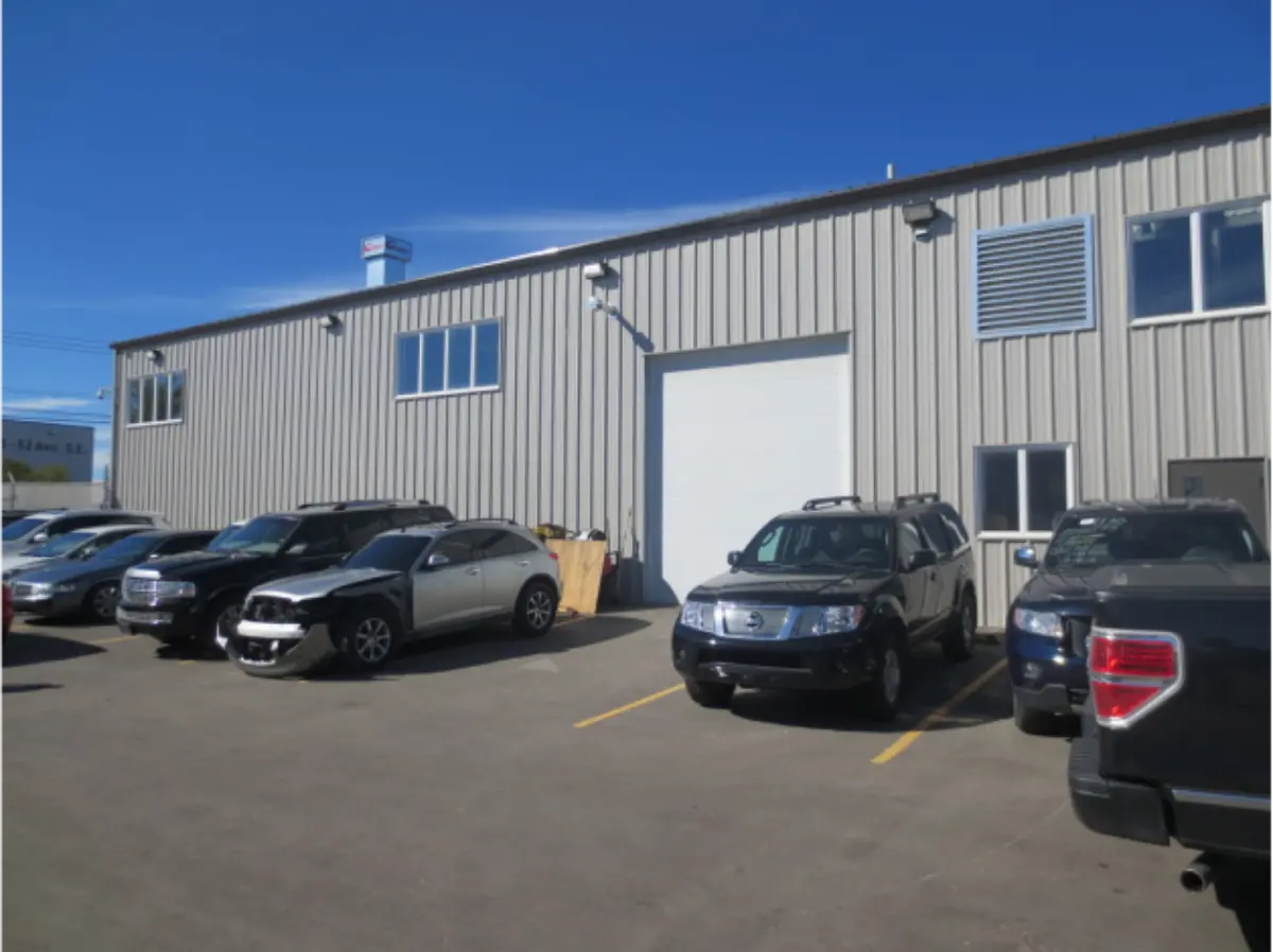 A row of cars are parked in front of a building