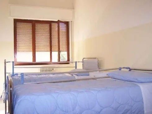 Una camera da letto con due letti e una finestra con le persiane.