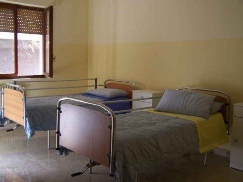 Una stanza d'ospedale con due letti e una finestra