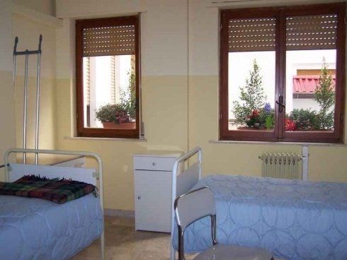 Una stanza d'ospedale con due letti e due finestre