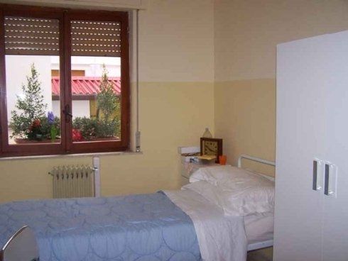 Una camera da letto con un letto e una finestra con le persiane