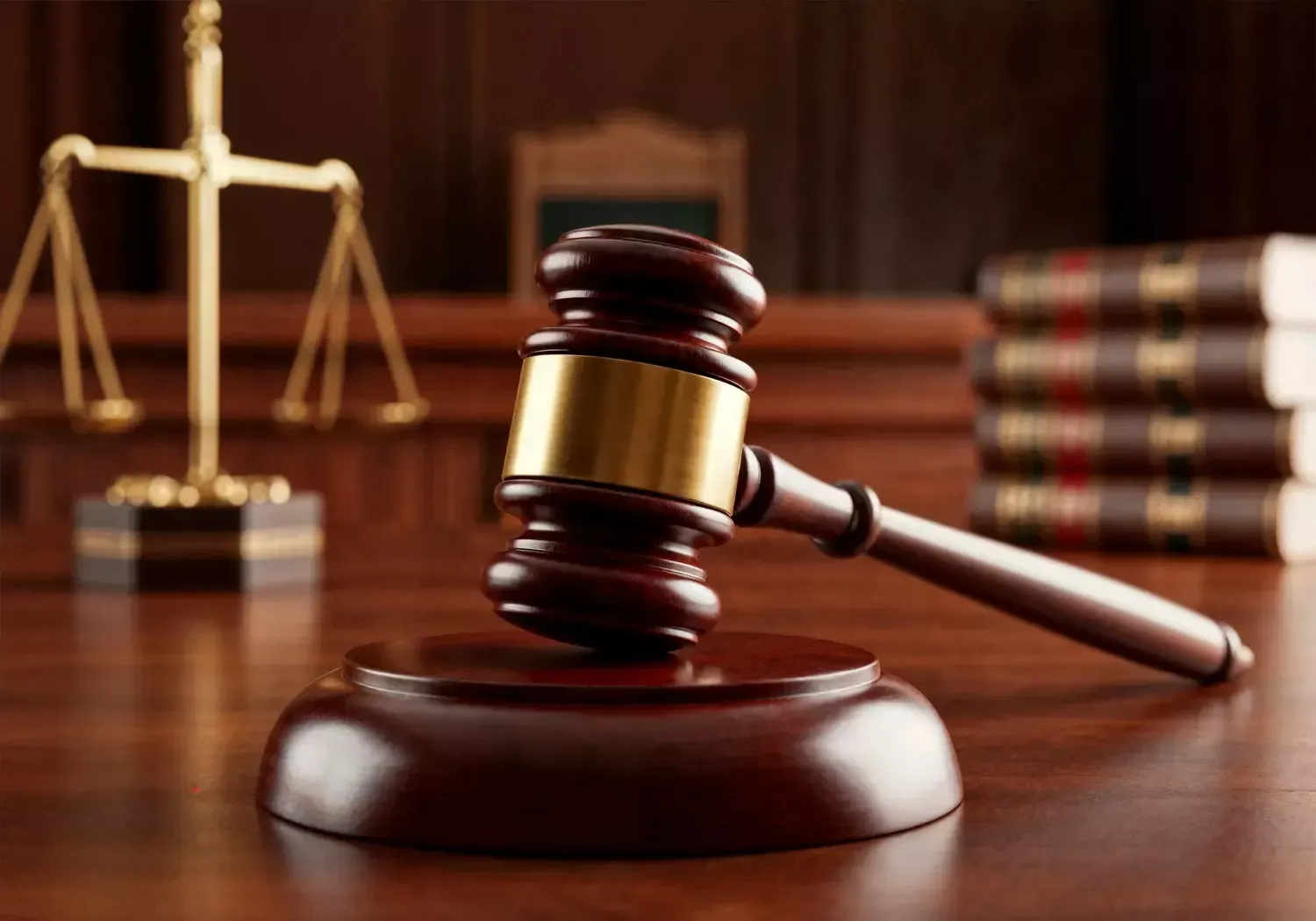 O martelo de um juiz está sobre uma mesa de madeira em um tribunal.