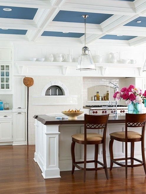 A kitchen with white cabinets and a blue ceiling