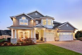 A large house with a lot of windows is lit up at night.