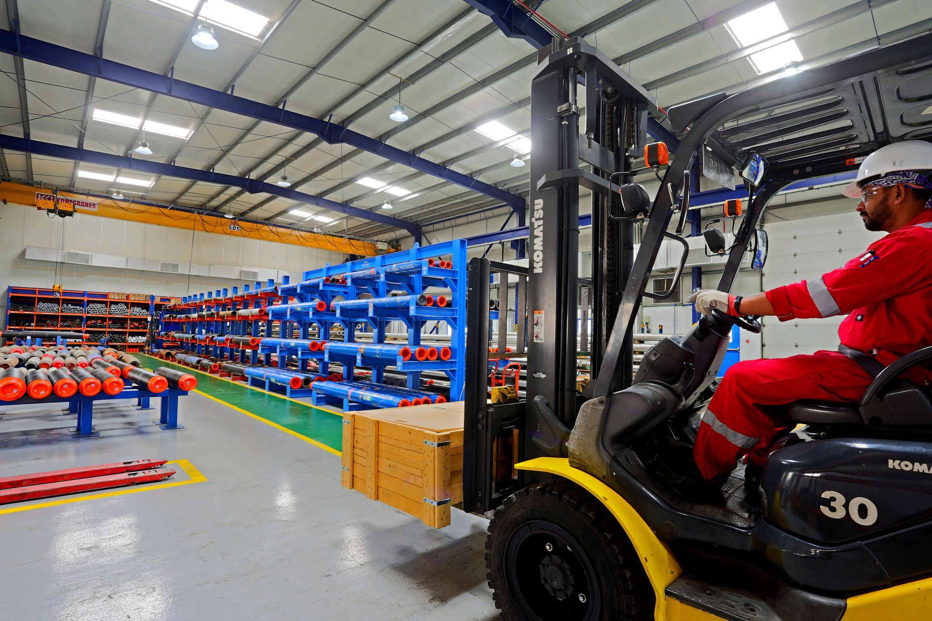 A man is driving a forklift in a warehouse.