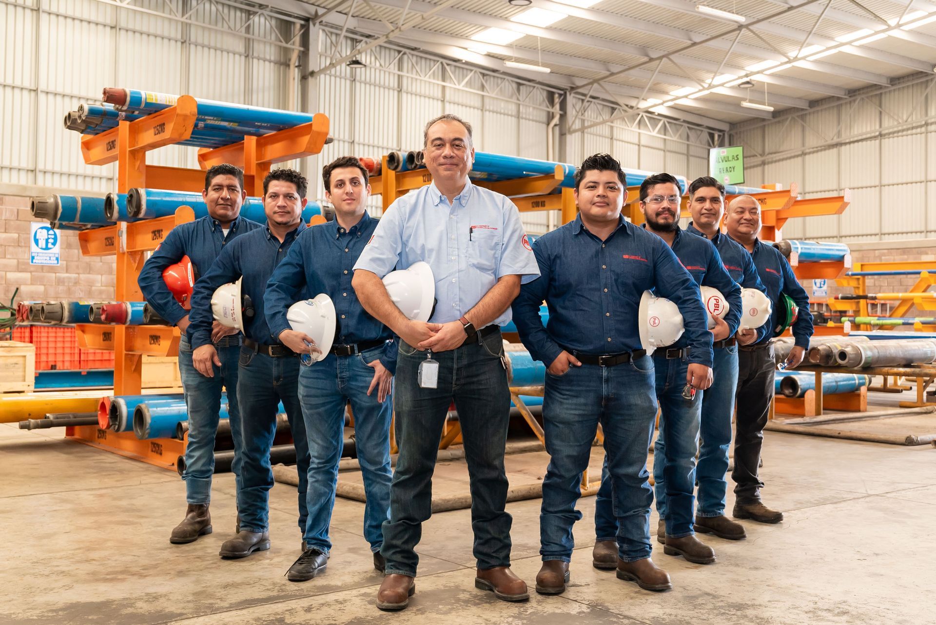 A group of men are posing for a picture in a warehouse.