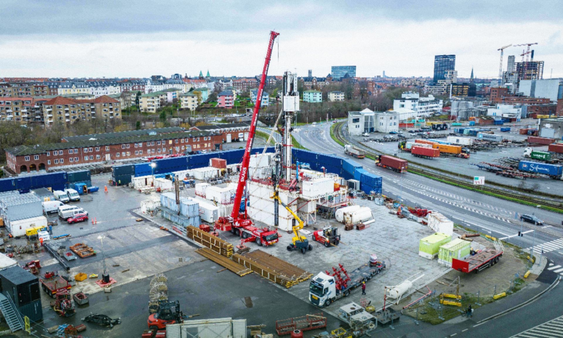 An aerial view of a construction site with a lot of trucks and cranes.
