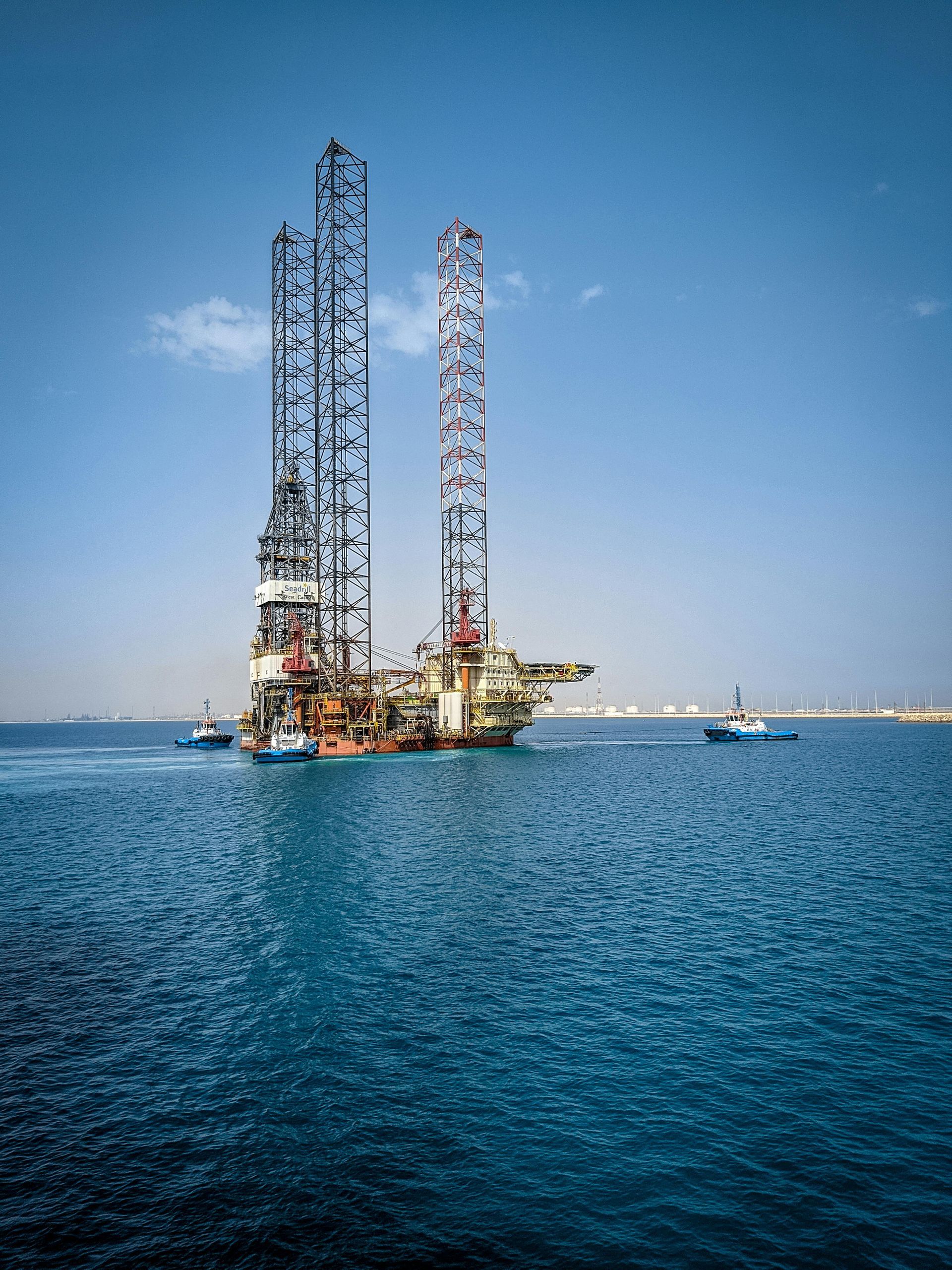 A large oil rig is floating in the middle of the ocean.