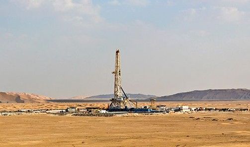 a large oil rig in the middle of the desert during the hot day in Qatar