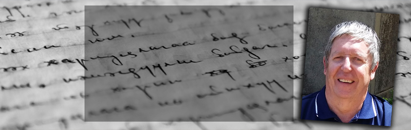 Man smiling, with a background of handwriting.