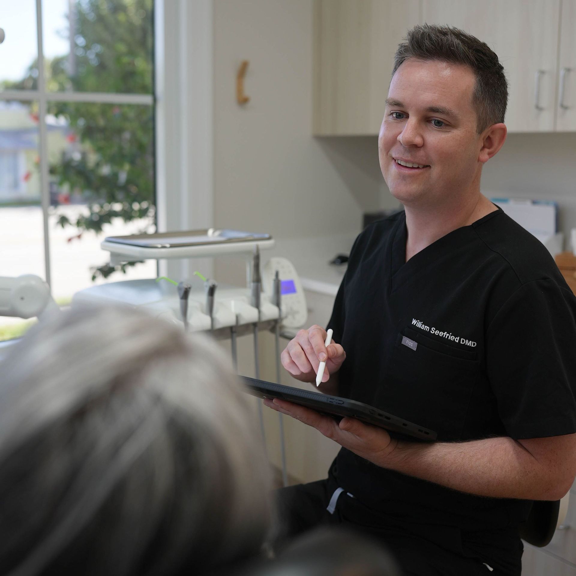 A woman is getting her teeth examined by a dentist