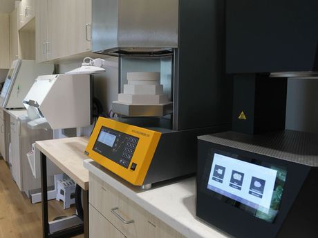 A row of dental equipment is sitting on a counter in a lab.
