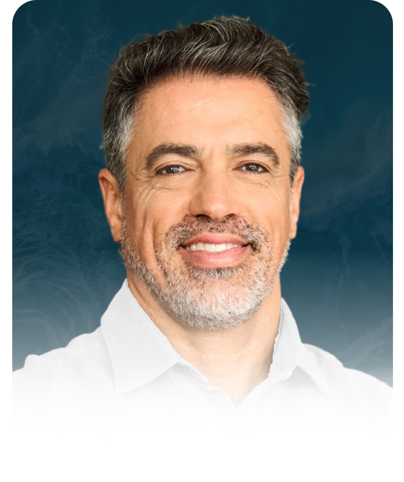 A man with a beard is wearing a white shirt and smiling