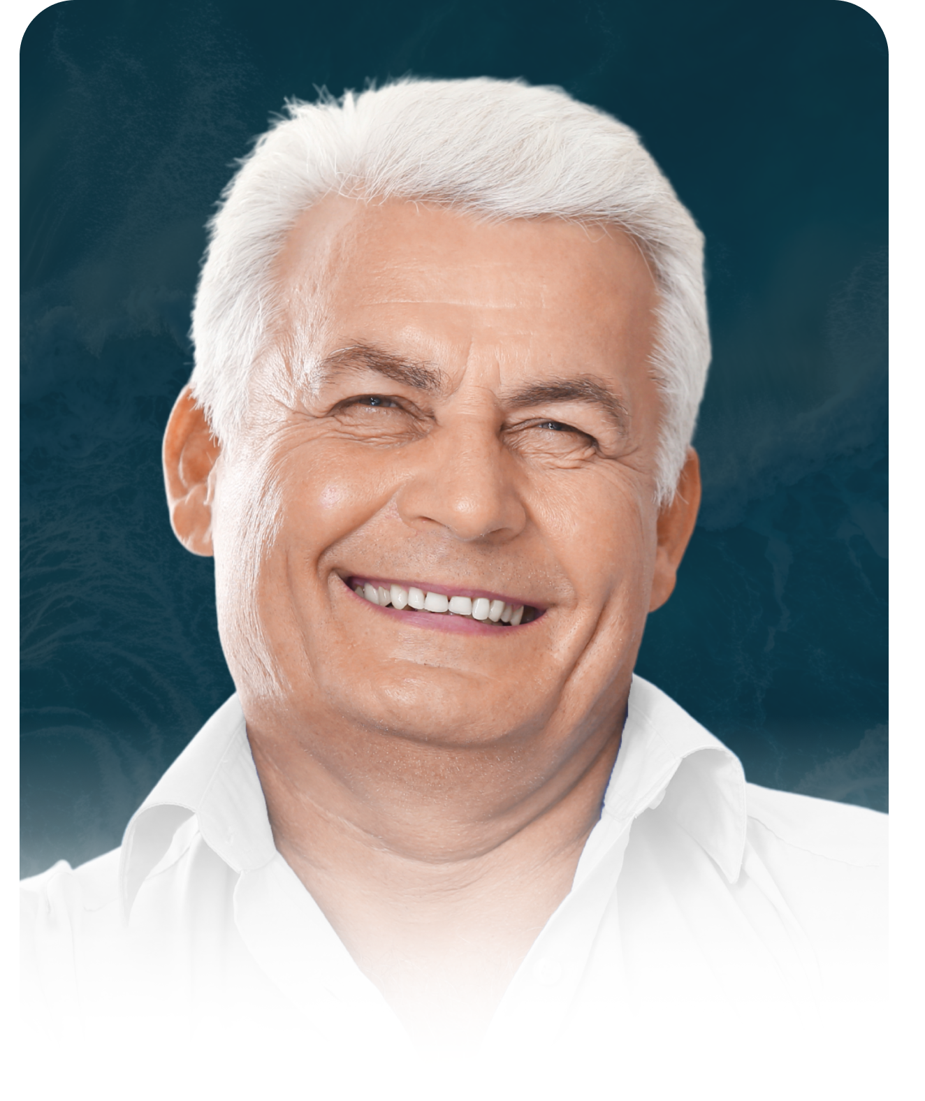 A man with white hair is smiling and wearing a white shirt