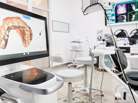 A dental office with a computer and a dental chair