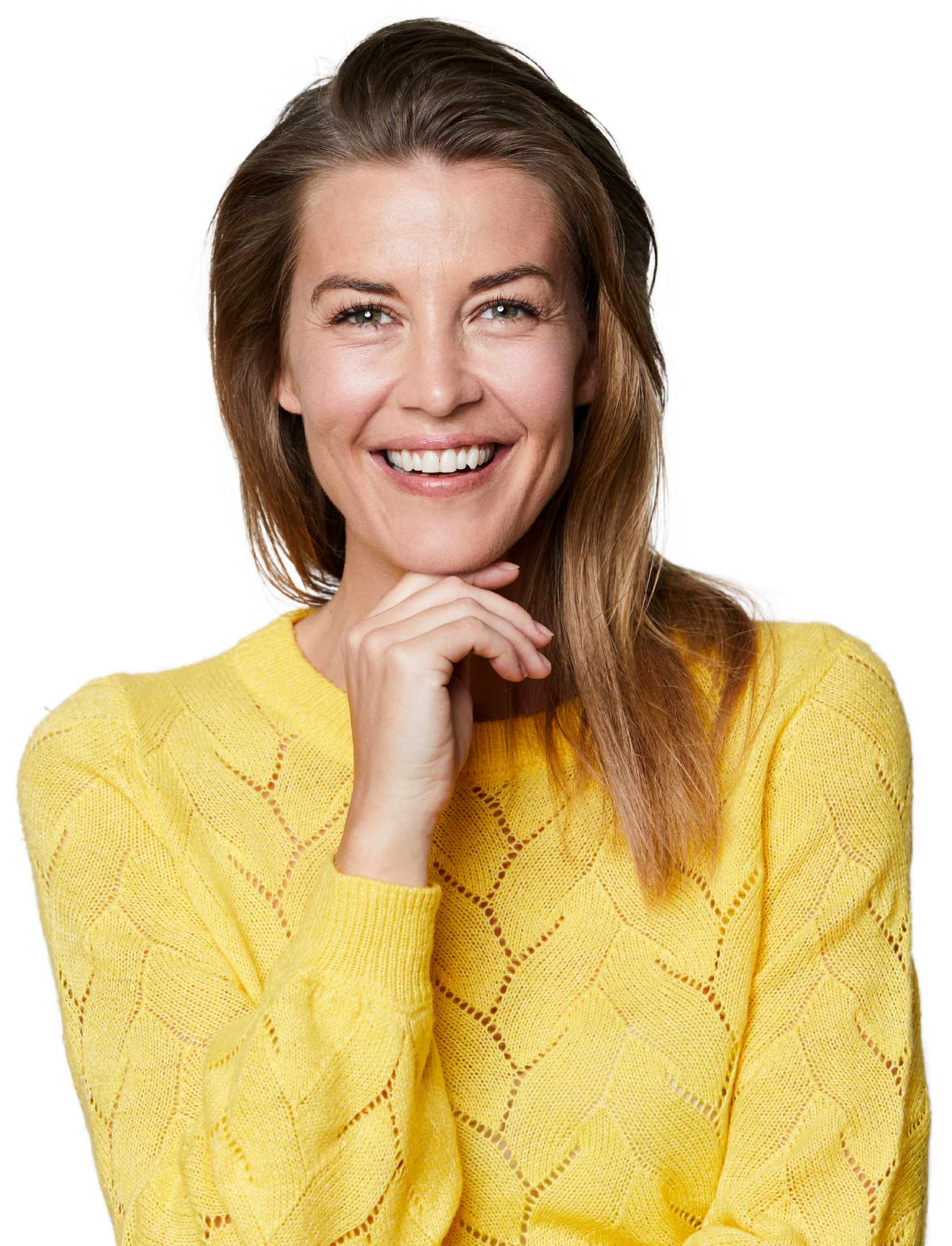 A woman in a yellow sweater is smiling with her hand on her chin